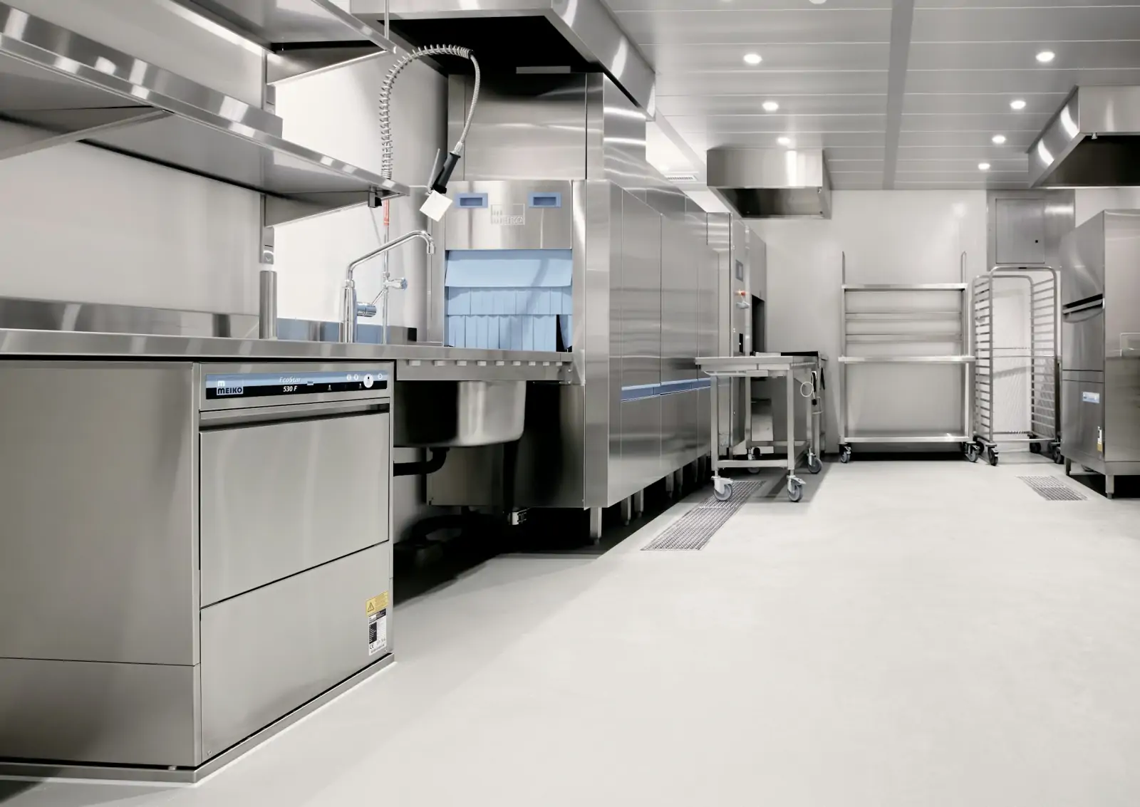 Stainless-steel commercial kitchen with prep counters and refrigeration